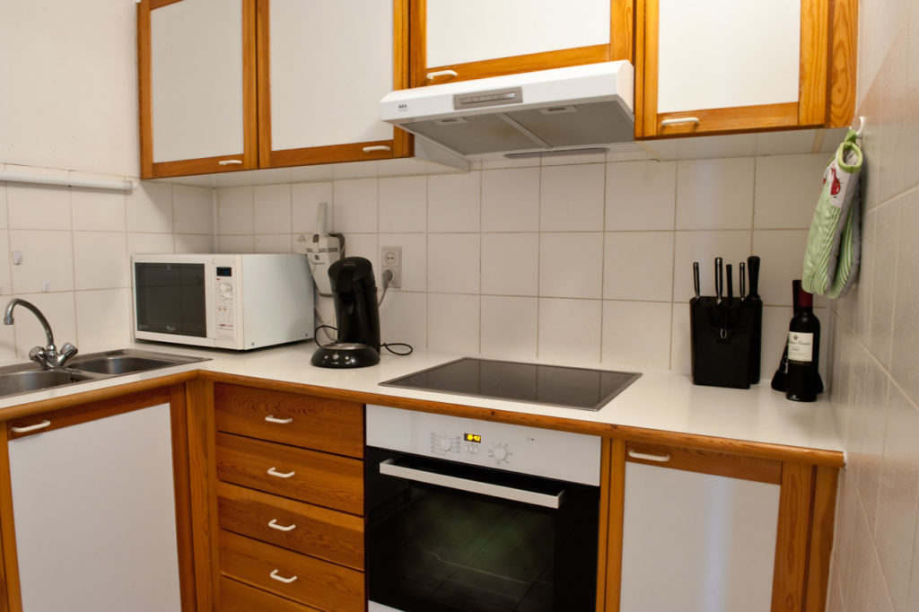 Keuken met moderne oven, kookplaat, microgolfoven, friteuse, vaatwasser.